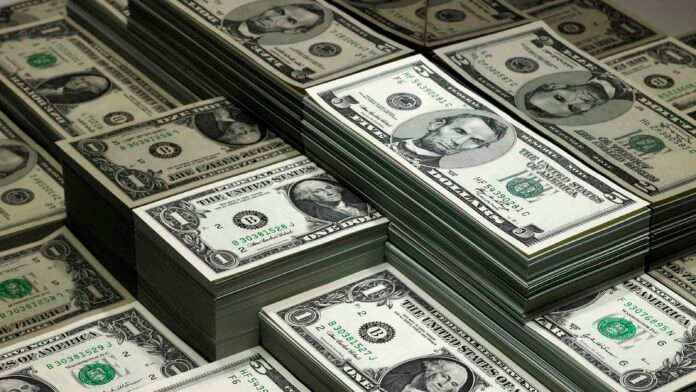 piles of dollar bills reflected in glass theinvestment.socialwits.in